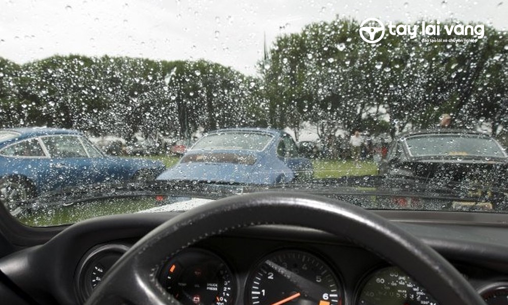 Bật cần gạt khi lái xe ô tô dưới trời mưa